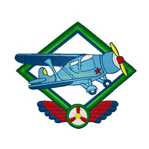 以下が含まれることがあります： プロペラと側面に赤い星が付いた青と赤の飛行機。緑色のひし形の枠の中にあり、その下に赤と緑のプロペラと翼がある。