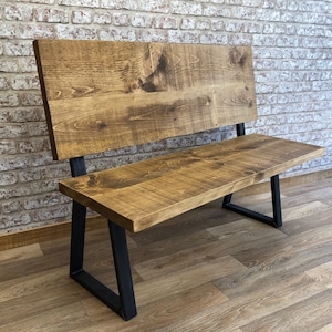 May include: A wooden bench with a backrest and black metal legs. The bench is made of reclaimed wood and has a rustic finish.