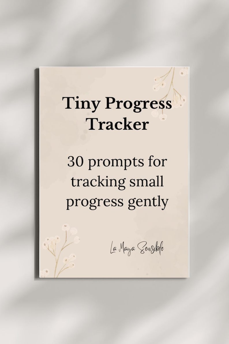 K&ouml;nnte beinhalten: Eine beige Karte mit dem Text "Tiny Progress Tracker" und "30 Anregungen zur sanften Verfolgung kleiner Fortschritte." Zarte Blumenillustrationen schm&uuml;cken die Ecken. Die Signatur "La Maya Sensible" befindet sich unten.