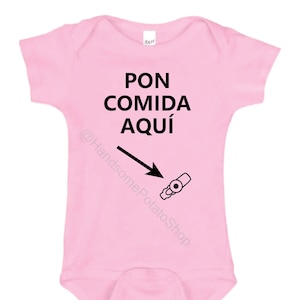 May include: Pink baby onesie with black text that says "PON COMIDA AQUÍ" with an arrow pointing to a baby bottle.