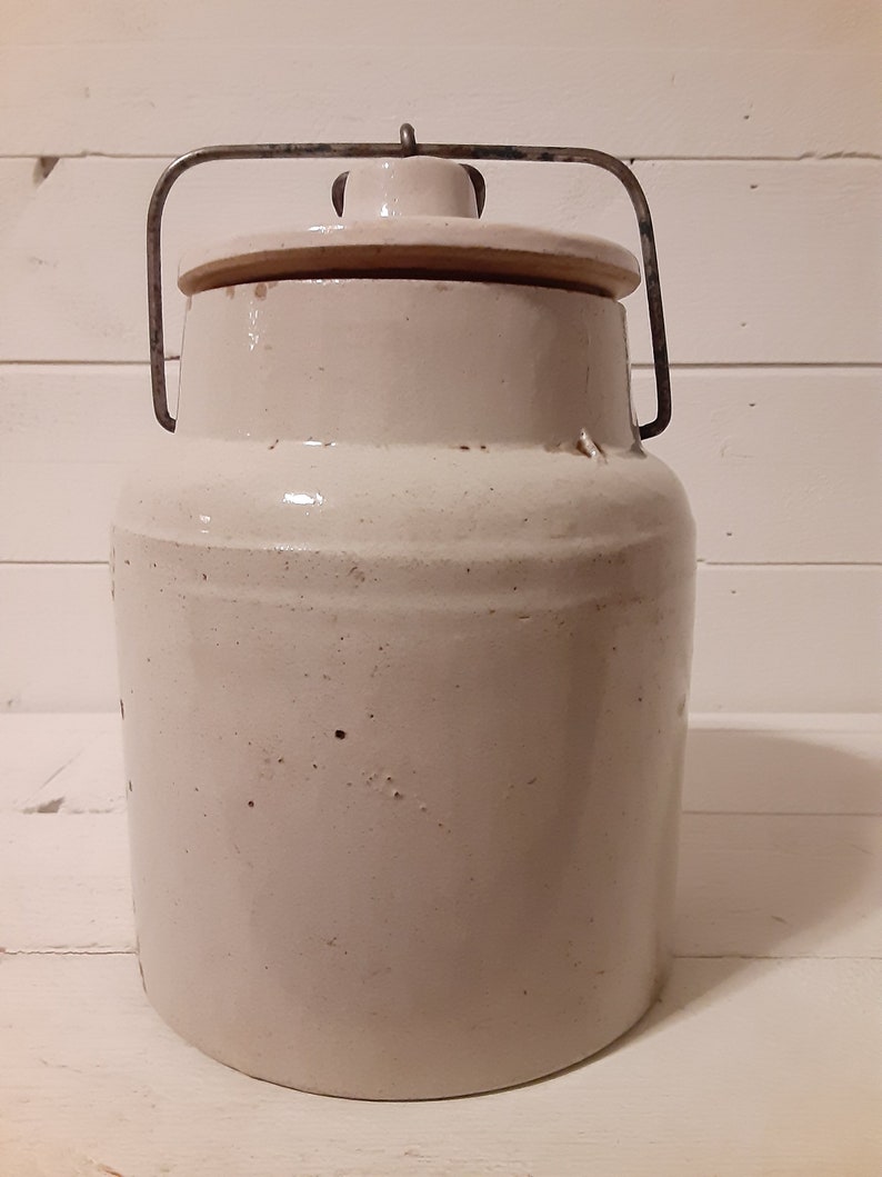 Puede incluir: Crock de cer&aacute;mica blanca con asa de alambre met&aacute;lico y tapa. El crock tiene un acabado esmaltado y est&aacute; ligeramente desgastado.