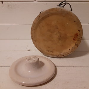 Puede incluir: Un tarro de cer&aacute;mica blanco con tapa. El tarro tiene un esmalte marr&oacute;n y un interior blanco. La tapa tiene un peque&ntilde;o pomo en la parte superior.