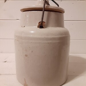 Puede incluir: Crock de cer&aacute;mica blanca con tapa y asa de metal. El crock tiene un dise&ntilde;o simple y est&aacute; en buen estado.