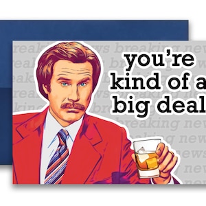 May include: A greeting card featuring a cartoon illustration of a man in a red suit and a mustache, holding a glass of whiskey. The text on the card reads "you're kind of a big deal".