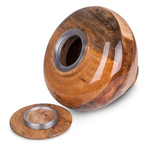May include: A wooden urn with a lid, featuring a natural wood grain pattern and a silver metal rim. The urn is open, revealing the interior.
