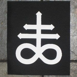 May include: White symbol on a black patch. The symbol is a cross with an infinity symbol at the bottom.