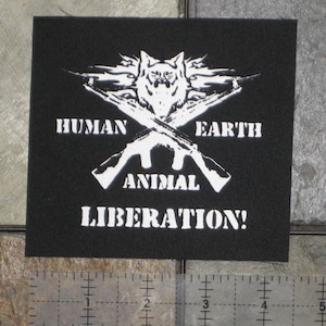 Puede incluir: Parche negro con texto blanco y un gráfico de lobo. El texto dice "Human Earth Animal Liberation!"