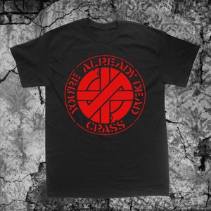 May include: Black t-shirt with a red circle graphic that says "YOU'RE ALREADY DEAD" and "CRASS" in a punk rock style.