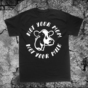 May include: Black t-shirt with a white graphic of a cow's head and the text "Not Your Mom Not Your Milk".