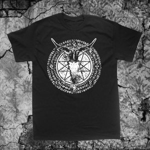 Puede incluir: Camiseta negra con un estampado gráfico blanco de una cabeza de cabra dentro de un círculo con símbolos y texto. El texto incluye las palabras "NOVVS ORDO SECLORVM".
