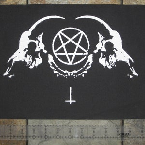 Könnte beinhalten: Weißer Patch mit einem Pentagramm, zwei Schädeln und einem Kreuz auf schwarzem Hintergrund.