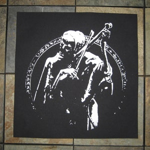 Könnte beinhalten: Schwarz-weiß-Patch mit einem stilisierten Bild einer Person, die Cello spielt. Die Person ist von einem Kreis mit Text in einer Fremdsprache umgeben.