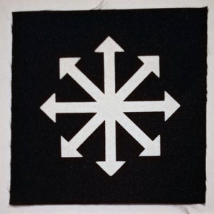 May include: A white eight-pointed star with arrows pointing in all directions on a black fabric background.