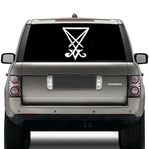 Könnte beinhalten: Ein silberner SUV mit einem weißen Pentagramm-Aufkleber auf der Heckscheibe.