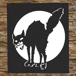 Op de afbeelding: Zwart-witte afbeelding van een katten silhouet tegen een witte cirkel, die lijkt op een volle maan. De kat is gebogen met zijn rug naar de kijker, en zijn staart is om de cirkel gekruld.