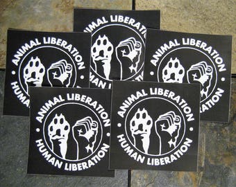 May include: Five black and white stickers with the text "Animal Liberation" and a graphic of two animal paws. The text "Human Liberation" is also included on the stickers.