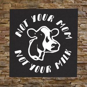 May include: Black and white graphic design on a black background with a cow and the text "Not your mom, not your milk".
