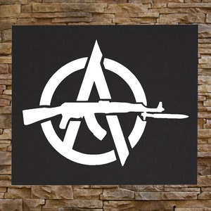 May include: A white anarchy symbol with a rifle inside the circle. The symbol is on a black background.