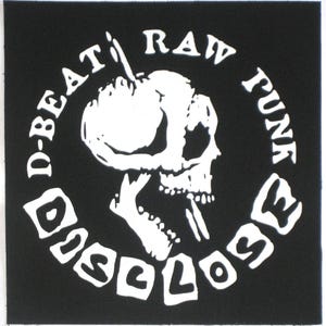 Peut inclure: Patch noir et blanc avec un motif de crâne et d'os croisés. Le texte autour du crâne dit "D-Beat Raw Punk Disclose".