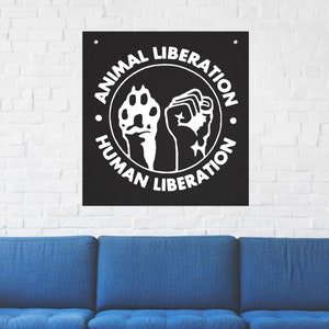 May include: Black and white poster with a circle containing a raised fist and a paw print. The text around the circle reads "Animal Liberation Human Liberation."