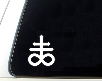 May include: White vinyl sticker of a symbol with a cross and an infinity symbol. The symbol is often associated with the occult.