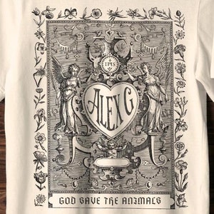 Alex G Gothic Shirt with a floral border and reads "Alex G" "God Save the Animals" from his newest album.