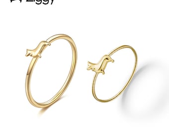 May include: Two gold-colored rings, each featuring a dachshund dog design. The rings are thin and delicate, with the dog charm positioned on the top of the ring. The brand name "Ziggy" is in the upper left corner.