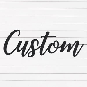 May include: Black cursive word "Custom" on a white wood background.
