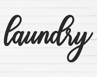 May include: Black cursive word "laundry" on a white wood background.