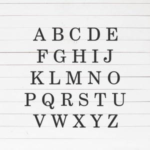 May include: Black and white alphabet letters A through Z displayed on a white wood panel background.