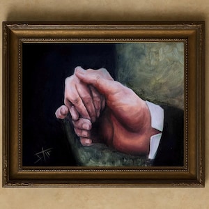 Puede incluir: Pintura al óleo de manos entrelazadas, en tonos cálidos, sobre un fondo oscuro. Las manos son el punto focal, con pinceladas detalladas que capturan la textura de la piel y la luz. La pintura está enmarcada en un marco dorado y ornamentado.