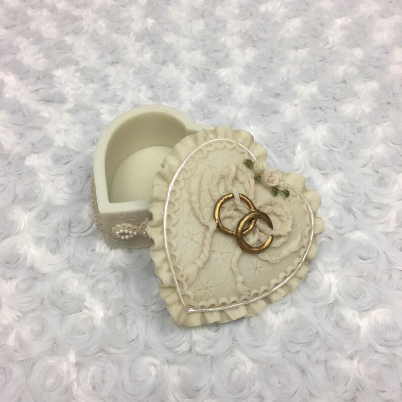 Caja de joyería en forma de corazón con anillos de boda de ...