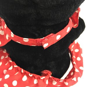 May include: Black plush toy with a red and white polka dot bow and a red and white polka dot dress.