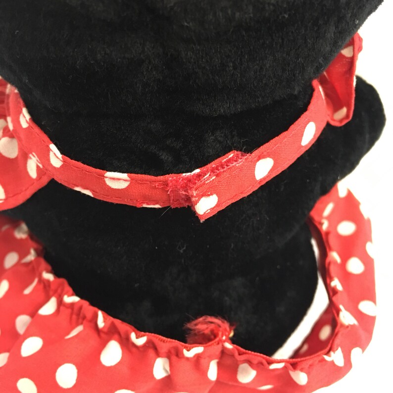 May include: Black plush toy with a red and white polka dot bow and a red and white polka dot dress.