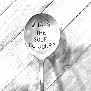 May include: A silver spoon with the text "What's the soup du jour?" engraved on the bowl.