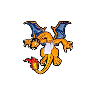 May include: A cartoon enamel pin of a orange and blue dragon wearing a white apron. The dragon has a surprised expression on its face and is holding a small cup in its hand.