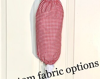 May include: Red and white gingham fabric bag dispenser hanging on a white door. The bag dispenser has a drawstring closure and a loop for hanging. The text "Custom fabric options" is visible at the bottom of the image.