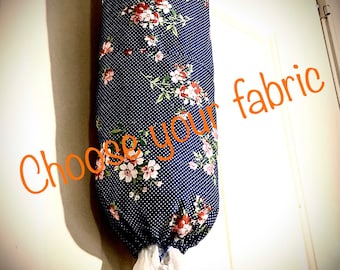 May include: A blue and white floral fabric bag dispenser with white polka dots. The bag dispenser is hanging on a white door. The text "Choose your fabric" is written in orange on the bag dispenser.