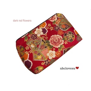 Op de afbeelding: Een rechthoekig, rood bloemenpatroon etui met een zwarte ritssluiting. De etui heeft een ontwerp van donkerrode bloemen, met accenten van wit, oranje en goud. De tekst "dark red flowers" staat aan de linkerkant en "abclovesu" aan de rechterkant.