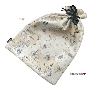 May include: A drawstring bag featuring a world map design. The bag is off-white with a beige map print, including landmarks and illustrations. It has a black drawstring closure. The text "map" and "abclovesu" are visible.
