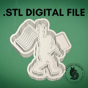 May include: A 3D digital file of a Bigfoot-like figure holding an American flag. The figure is in a cutout design with the text ".STL DIGITAL FILE" at the top. The design includes the text "2/4 FOXY DESIGNS COMBAT VETERAN OWNED" in a circular logo.