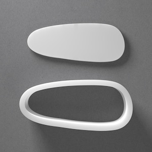 May include: Two white, abstract, oval-shaped objects are shown against a grey background. One is solid, and the other is an open frame. The objects appear to be made of a smooth, matte material.