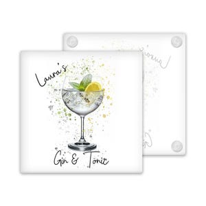 May include: White ceramic coaster with a watercolor-style illustration of a gin and tonic drink with a lemon wedge. The text "Laura's Gin & Tonic" is printed on the coaster.