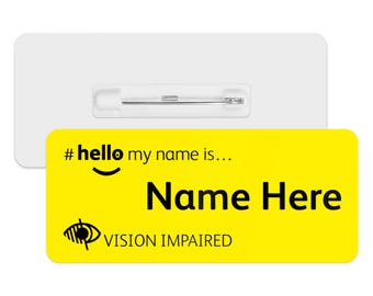 May include: Yellow name tag with a pin on the back. The tag says "#hello my name is... Name Here VISION IMPAIRED" with a smiley face and a symbol of a crossed-out eye.