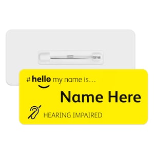 May include: Yellow name tag with a black hashtag, smiley face, and the text "#hello my name is... Name Here HEARING IMPAIRED". The tag has a pin on the back.