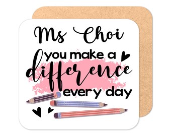 May include: A white square coaster with the text "Ms. Choi you make a difference every day" in black cursive font. A pink watercolor-style background with three colored pencils is behind the text. Two small hearts are below the pencils.