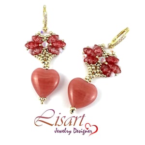 Può includere: Orecchini color oro con pendenti a forma di cuore rossi. Gli orecchini presentano un gruppo di perline e cristalli rossi sopra le pietre a forma di cuore. Gli orecchini sono di Lisart Jewelry Designer.