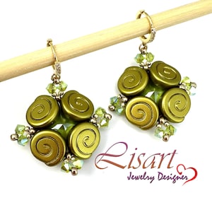 May include: Olive green beaded earrings with a spiral design. The earrings have gold-coloured hoops and are accented with small green crystals. The earrings are displayed on a wooden dowel against a white background.
