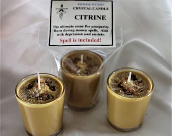 May include: Three small glass candle jars with golden yellow wax and a white wick. The wax has small pieces of citrine crystals embedded in it. The jars are labeled "Power Within Crystal Candle Citrine. The ultimate stone for prosperity. Burn during money spells. Aids with depression and anxiety. Spell is included!"