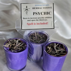 May include: Three purple votive candles with dried herbs and a label that reads "POWER WITHIN HERBAL VOTIVE PSYCHIC Burn to increase psychic abilities and open the third eye. Spell is included!"